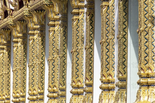 Columns with mosaic decorations (Lai Kranok), also: golden, mosaic-decorated Thai temple columns (Sao), decorated in Lai Kranok style, typical of Rattanakosin architecture (Bangkok style), on the outer façade of the Ubosot (ordination hall), Wat Chana Songkhram, Phra Nakhon, Bangkok, Thailand