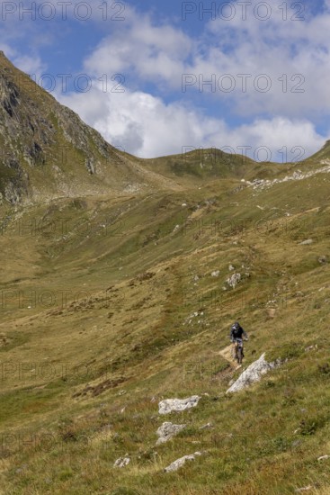 Mountain biker on the trail downhill at Passo del Sole, Olivone, Tessin, Switzerland