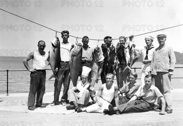 Group of men posing with various captured groupers and mackerel, around 1930s, Florida, USA