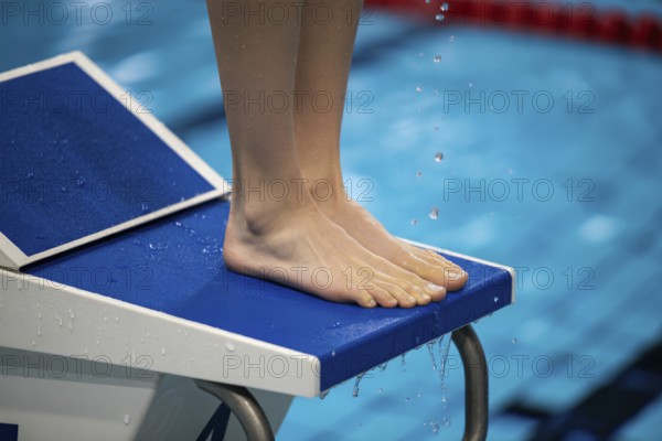 Feet of a woman on a starting block in a swimming pool. Preparation for competition and athletic focus. Generative AI, AI generated