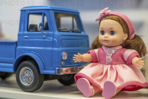 Cute doll in pink dress and blue toy car. Gender stereotypes in children's toys and color coding criticism. Generative AI, AI generated