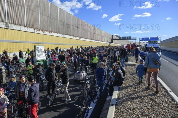 Cyclists at a demo on the 16th construction phase of the A100. Participants walk on the elevated central strip. Sign on a cargo bike: Move fairly instead of laying concrete. Berlin, 18.10.2025