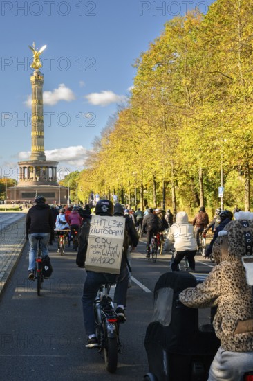 Participants in a bicycle demo against the A100 on the 17th of June road. Signs say: Hitler loves (little heart) Autobahn, CDU continues the delusion #A100, Victory Column, Berlin, 18.10.2025
