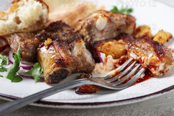 A plate with leftover pork kebab, with bread, on a white plate, close-up, there are no people
