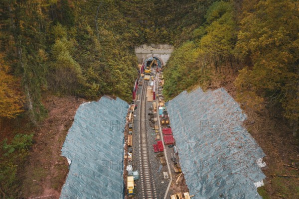 Rail construction in front of a tunnel in an autumn forest, viewed from above, Hermann-Hesse-Bahn construction site, Calw, Germany