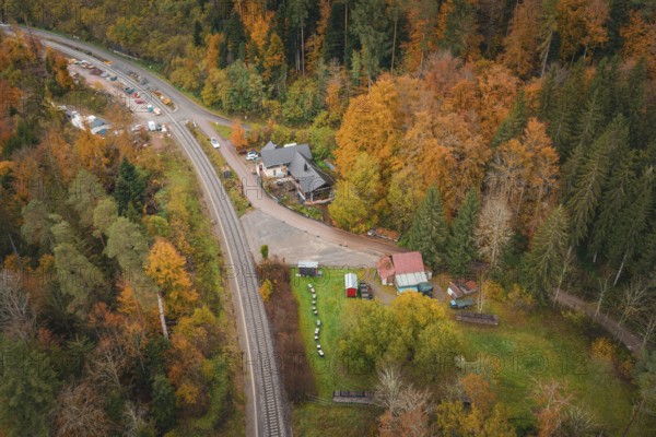 Railway line and buildings in autumn forest, village atmosphere, Hermann-Hesse-Bahn construction site, Calw, Germany