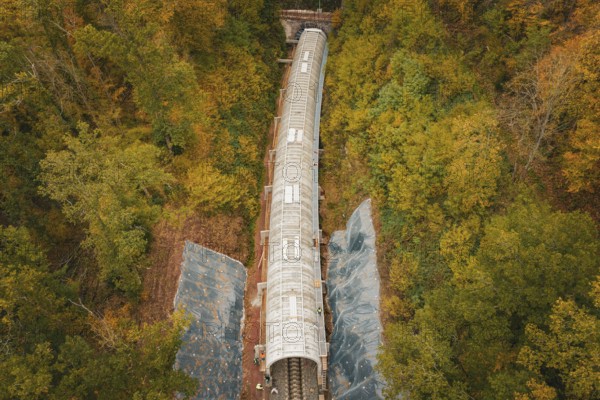 Railway line with safety tunnel nestled in an autumnal forest, Herman-Hesse-Bahn construction site, Calw, Germany