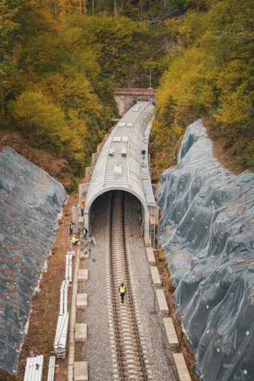 Railway line with partial tunnel in autumn surroundings with construction workers, Hermann-Hesse-Bahn construction site, Calw, Germany
