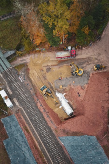 Construction work with heavy machinery on a railway line in autumn forest, Hermann-Hesse-Bahn construction site, Calw, Germany