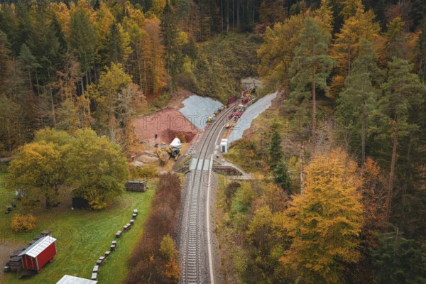 Route of railway tracks in autumn forest landscape with tunnel construction project, Hermann-Hesse-Bahn construction site, Calw, Germany