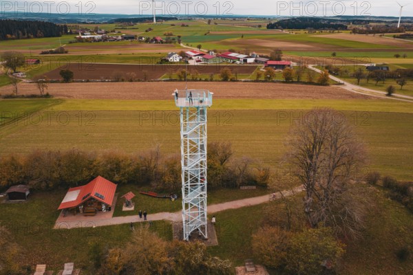 An observation tower in the middle of a rural landscape with fields and buildings, surrounded by autumn colors, Dürrenmettstetten observation tower, Germany