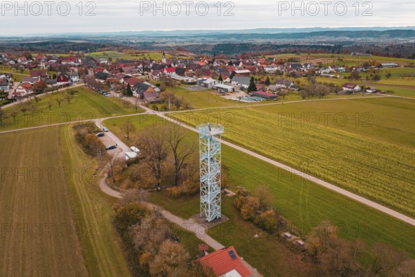 Rural landscape with an observation tower and a village in the distance, crossed by fields and trails, Dürrenmettstetten observation tower, Germany