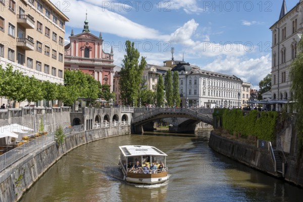 River Ljubljanica, sightseeing boat with passengers, triple bridge (Tromostovje), Ljubljana, Slovenia