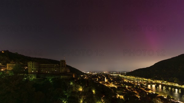 Nocturnal sky with aurora borealis over Heidelberg. Heidelberg Castle on the left, the Neckar river on the right. Rhein-Neckar District, Baden-Württemberg, Germany