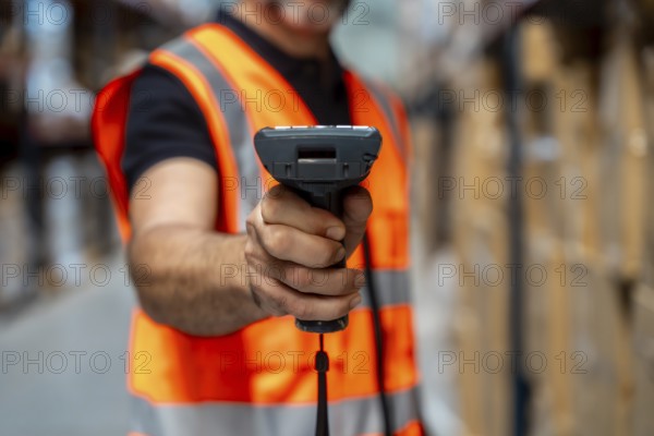 Warehouse worker wearing a safety vest using a barcode scanner to manage inventory and streamline logistics operations in a modern distribution center with racks and packages