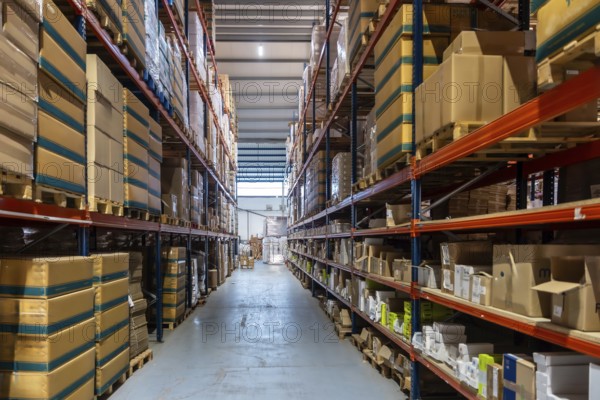 Storage warehouse interior filled with numerous cardboard boxes and products stacked on tall racks, representing efficient inventory management and supply chain operations for businesses