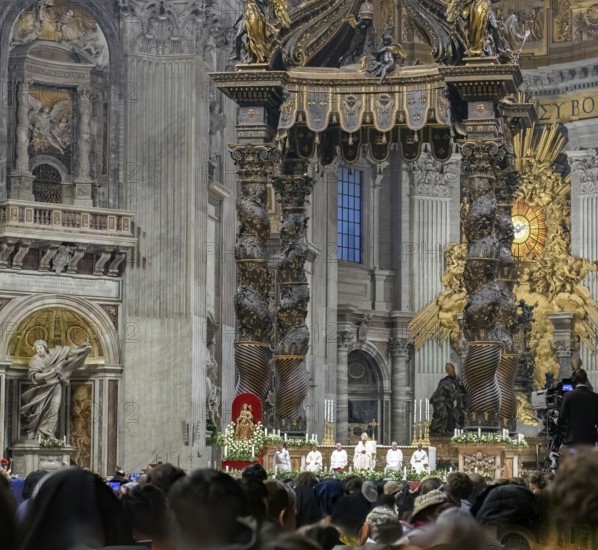 View of heads of faithful in the foreground at the bottom of the picture is Pope Saint Father with white robe and mitre on head under Bernini's tomb celebrating Saint Mass in St. Peter's Basilica, Basilica of St. Peter, Vatican, Rome, Lazio, Italy