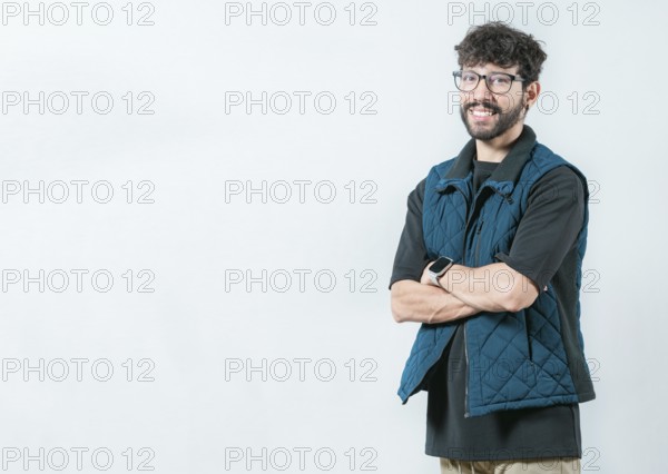 Smiling and handsome guy with glasses holding arms crossed isolated. Portrait of cool and handsome casual man with glasses and crossed arms