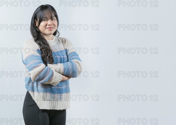 Attractive young Asian woman with arms crossed isolated. Portrait of beautiful and smiling Asian woman on white background