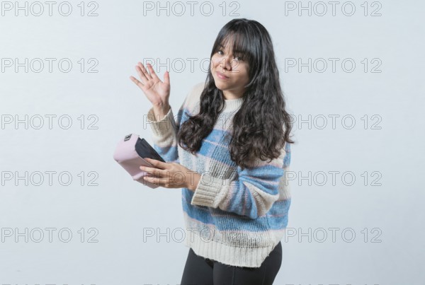 Worried girl with no money holding empty wallet, isolated. Young woman shaking her empty wallet