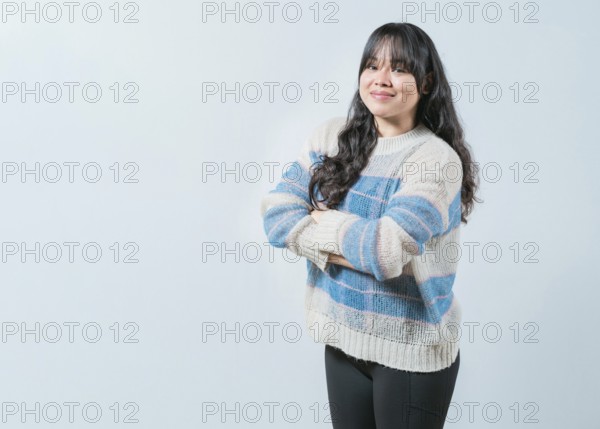 Portrait of beautiful and smiling Asian woman on isolated background. Young Asian female with crossed arms isolated