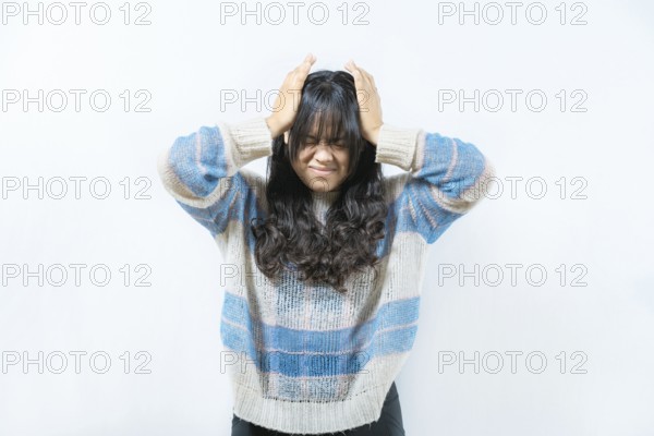 Unhappy woman with headache isolated. Painful girl with migraine holding his head isolated