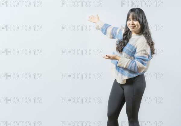 Smiling asian woman presenting something, isolated. Happy girl welcoming you on isolated bakground