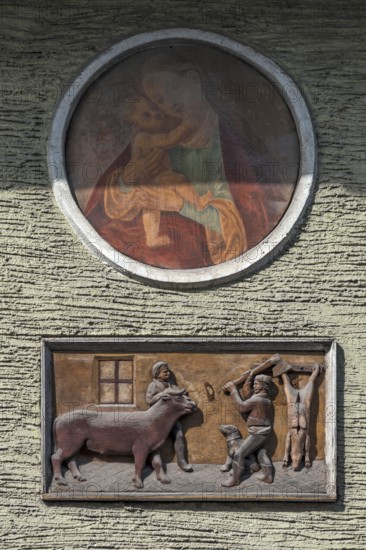 Relief depiction of a house slaughter above a saint at a town house, Going am Wilden Kaiser, Tyrol, Austria