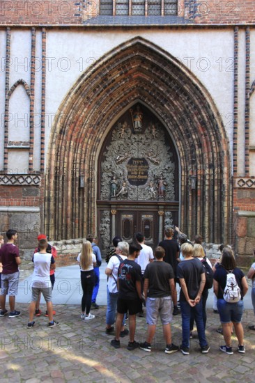 Tourist group in front of the portal of St. Nicholas Church, also St. Nicholas Church, in the city area of Altstadt, Stralsund, Vorpommern-Rügen district, Mecklenburg-Western Pomerania, Germany