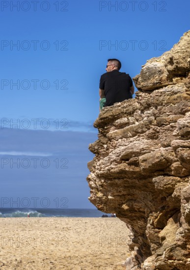 Tourists watch the waves of the Atlantic on the rocky plateau of Sito, also known as Forte São Miguel, a surfing paradise with monster waves in the months of November to February, Nazaré, Portugal