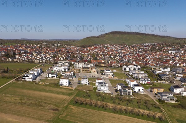 View of city with new development area, red roofs and surrounding green hills in the background, Korb im Rems Valley, Baden-Württemberg, Germany