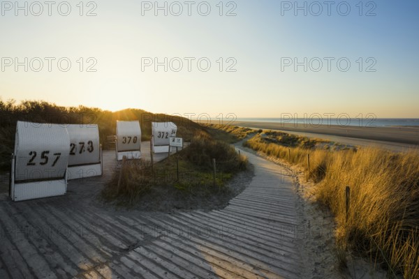Beach chairs in the dunes and blue sky in winter, sunset, Spiekeroog, East Frisian Islands, Lower Saxony, Germany