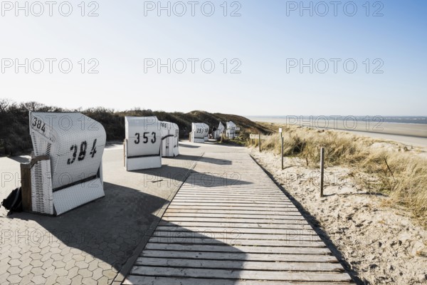 Beach chairs in the dunes and blue sky in winter, Spiekeroog, East Frisian Islands, Lower Saxony, Germany