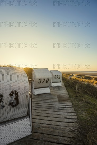 Beach chairs in the dunes and blue sky in winter, sunset, Spiekeroog, East Frisian Islands, Lower Saxony, Germany