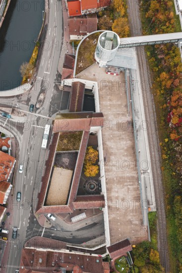 Aerial view of a building complex at an intersection with bridge and railroad tracks in autumn, ZOB Calw, Hermann Hessebahn, Calw, Germany
