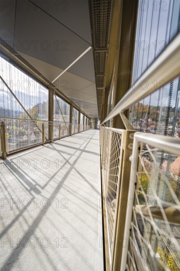 Modern bridge with long shadows and a network of metallic mesh along the sides, ZOB Calw, Hermann Hessebahn, Calw, Germany