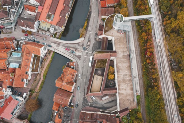Aerial view of a city with a river and bridges, surrounded by autumn-colored trees, ZOB Calw, Hermann Hessebahn, Calw, Germany