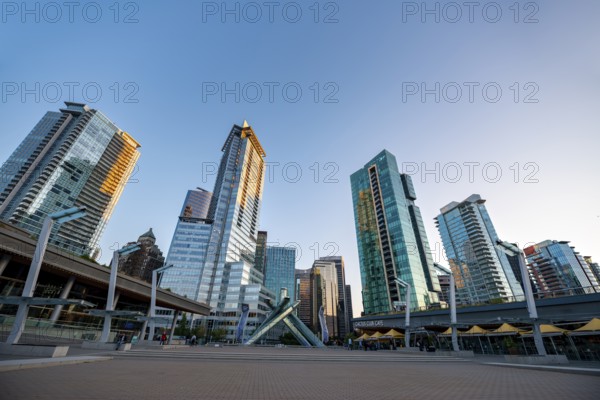 Olympic Cauldron Statue, Jack Poole Plaza Square, skyscrapers on the promenade at sunset, Coal Harbour, Vancouver, British Columbia, Canada