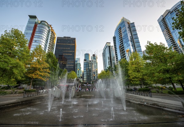 Fountain in Spray Park and SkyLine with skyscrapers at sunset, Harbour Green Park, Vancouver, British Columbia, Canada
