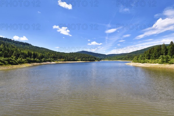 Beautiful mountain lake in the Black Forest in Forbach in Germany called Schwarzenbach Reservoir surrounded by forested hills under a clear sky