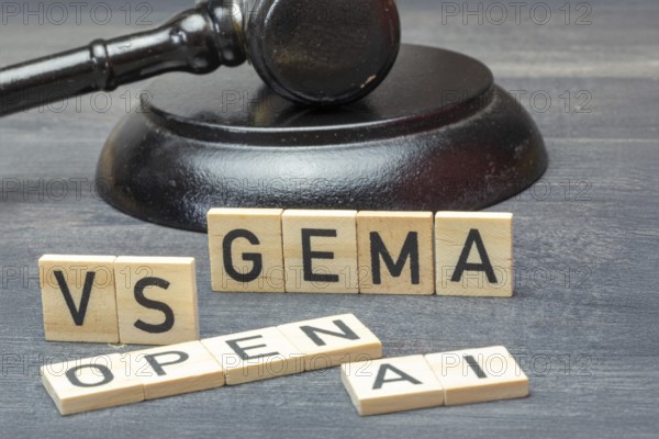 Letter cubes in front of a judge's hammer show the words GEMA VS OPEN AI