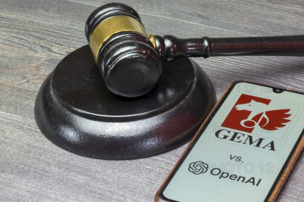 Smartphone with GEMA and OpenAI logo next to a judge's hammer
