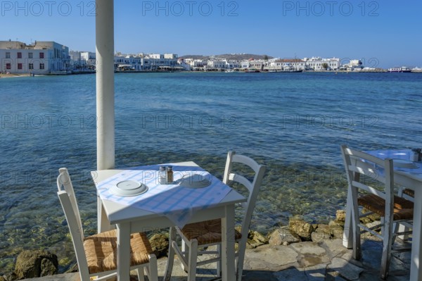 Mykonos, Cyclades, Greece - Small picturesque tavern right on the waterfront, on the harbor in the old town of Mykonos Town, Mykonos Chora. Mykonos is part of the Cyclades archipelago