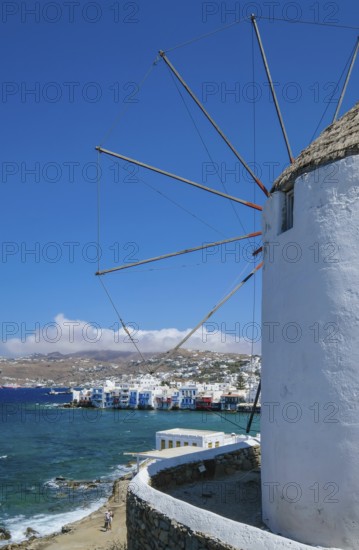 Mykonos, Cyclades, Greece - The six sixteenth-century windmills, lined up on a hill above Mykonos Town, Mykonos Chora, are the island's landmark. At the back, right by the sea, are the colorful houses of Little Venice. Mykonos is part of the Cyclades archipelago in the Aegean Sea