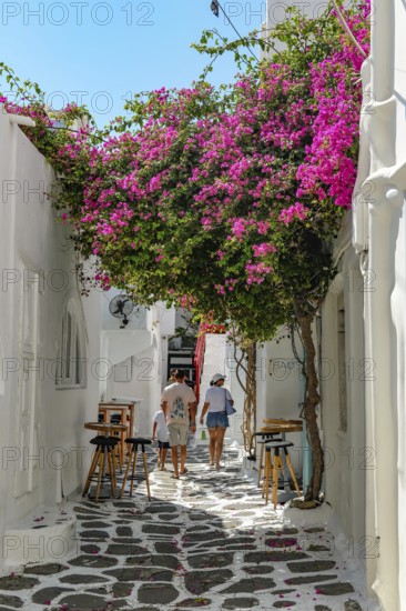 Mykonos, Cyclades, Greece - Tourists stroll through colorful alleys of the old town in Mykonos Town. Mykonos is part of the Cyclades archipelago in the Aegean Sea