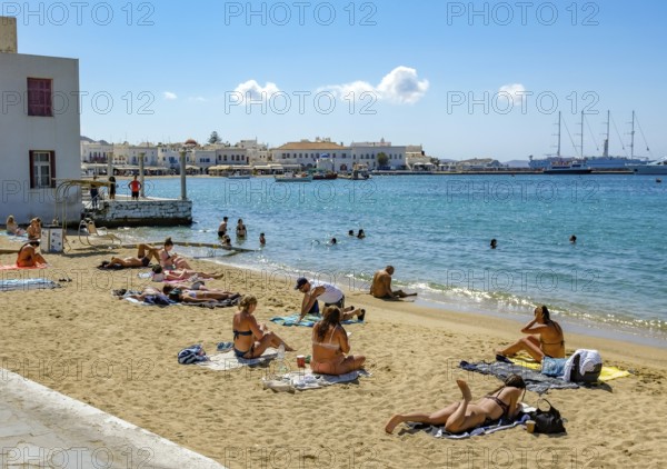 Mykonos, Cyclades, Greece - Tourists and locals like to bathe at the small town beach Paralia Cheras Mikonou right at the old port in the old town of Mykonos Town, Mykonos Chora. Mykonos is part of the Cyclades archipelago