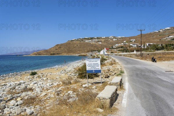 Mykonos, Cyclades, Greece - Choulakia is a beach in Dimos Mykonos. About four kilometers north of Mykonos Town, on the west coast of the island, is Choulakia, a natural rocky beach with emerald green water. The beach is located on the way to Armenistis lighthouse in the north of the island, a landmark and a popular destination for tourists. An information sign prohibits taking the stones