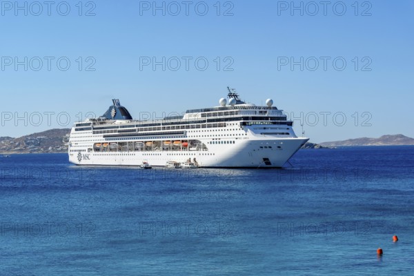 Mykonos, Cyclades, Greece - Cruise ship MSC Lirica is located in Mykonos Harbour Bay. Cruise ships bring tourists to shore