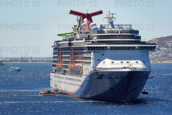 Mykonos, Cyclades, Greece - cruise ship CARNIVAL MIRACLE is located in the bay off Mykonos Town. Cruise ships bring tourists to shore