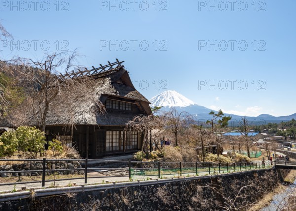 Iyashinosato open-air museum, old Japanese village with traditional houses, at the back volcano Mt. Fuji, Fujikawaguchiko, Saiko, Japón